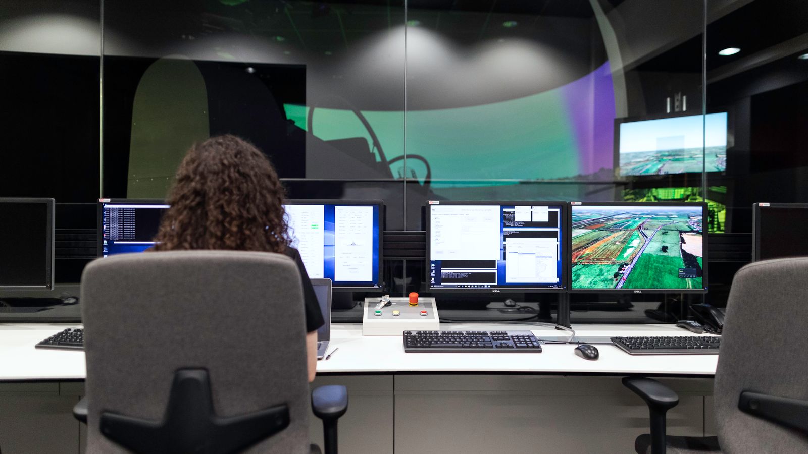 Leitstand mit mehreren Monitoren zur Überwachung laufender Systeme